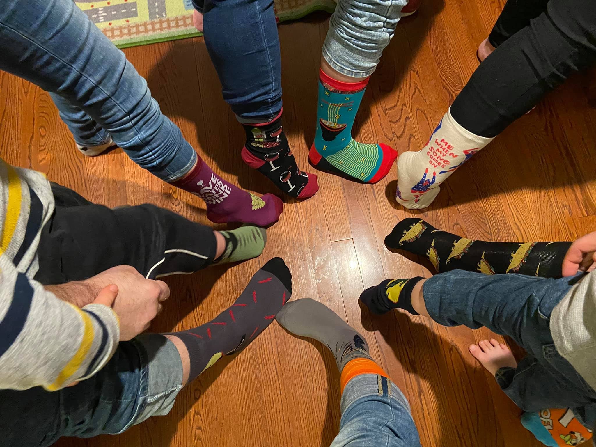a group of people's feet posing in a circle showing off their socks for world down syndrome say