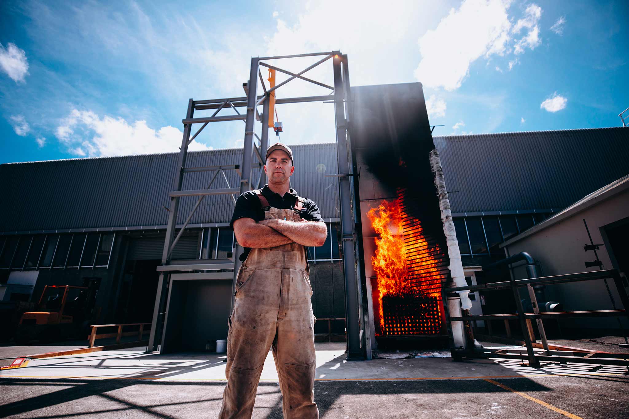 Photo of a fireman standing in front of a structure that is on fire.