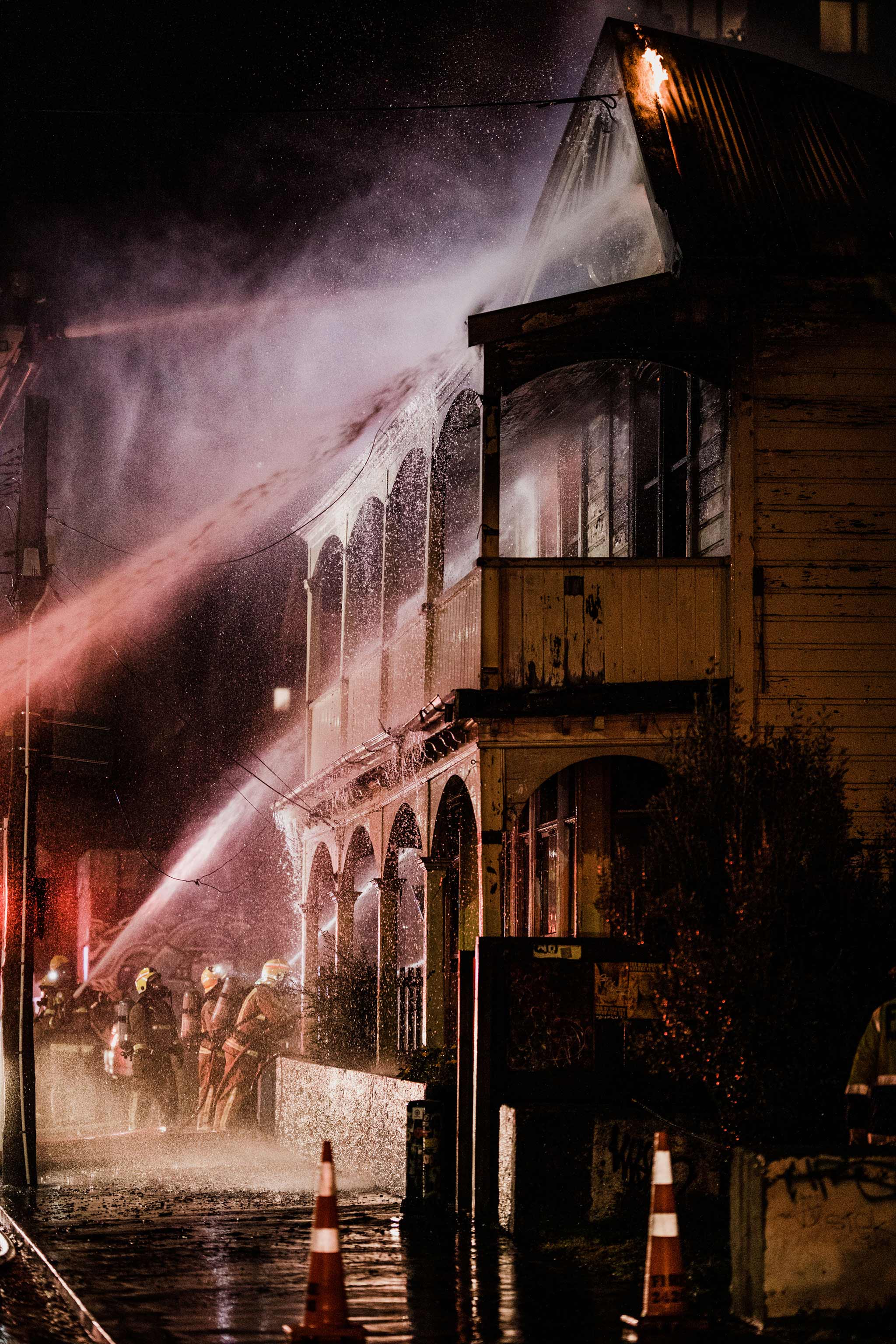 Photo of fireman spraying water on a burning house.