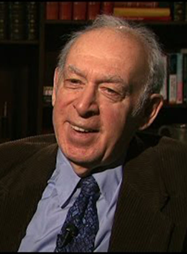 Jerome I. Friedman seated in front of a black background for an on camera interview.
