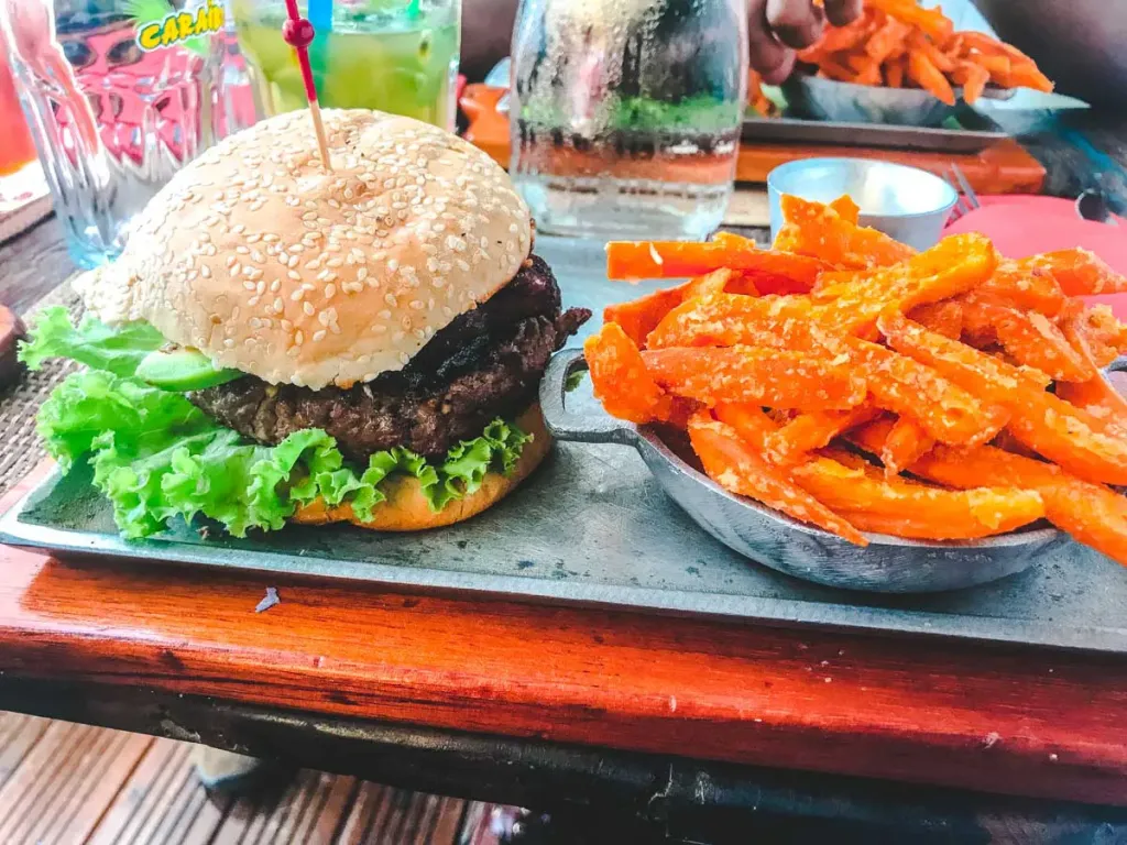 Eating a delicious burger with sweet potato fries.