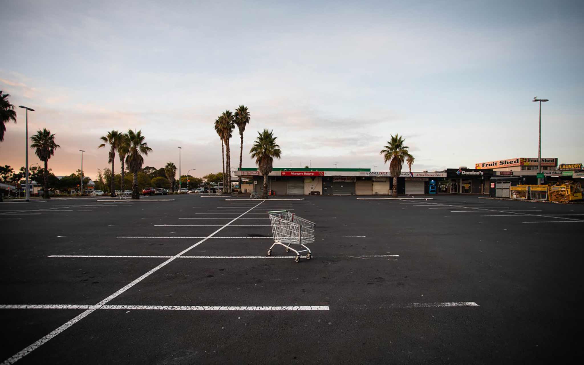 Photo of an empty car park with a sole shopping trolley in the middle.