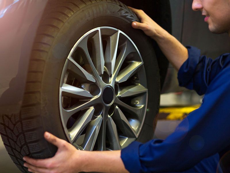 Car-mechanic-in-workshop-changing-tires.jpg