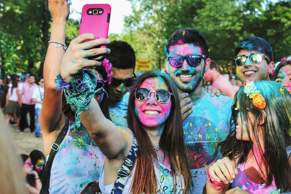 A group of friends taking a selfie together at a paint festival.
