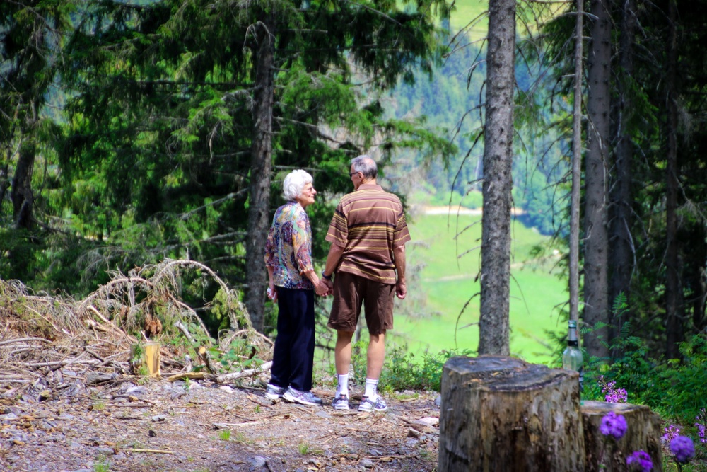 Elderly couple holding hands in the woods