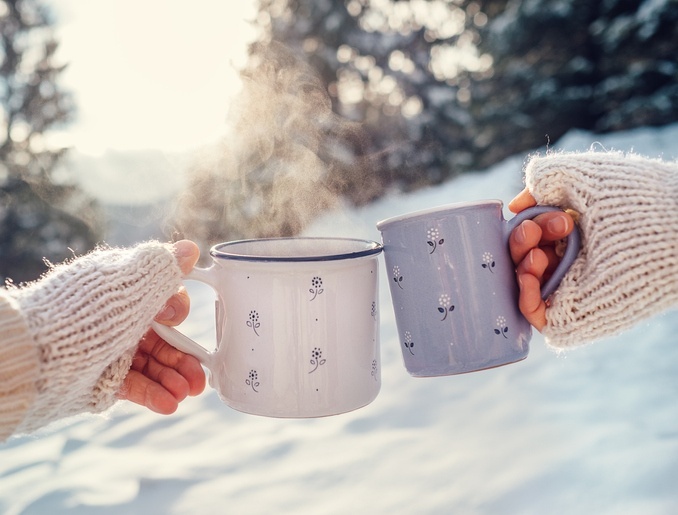 Couple holding mugs of hot chocolate during a Christmas date.jpg