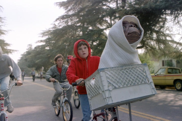 Screen grab from E.T. of boy riding bicycle with alien in a basket on the front