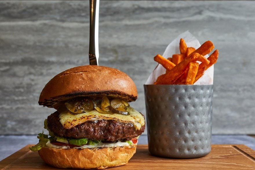 Aged ribeye and chuck brioche burger, melted cheese and pickled cucumber, sweet potato fries