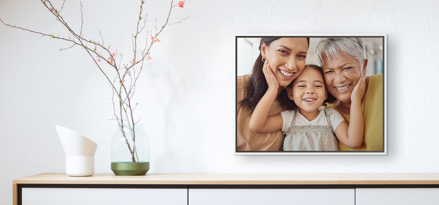 A framed canvas print displaying a photo of 3 generations of women smiling 