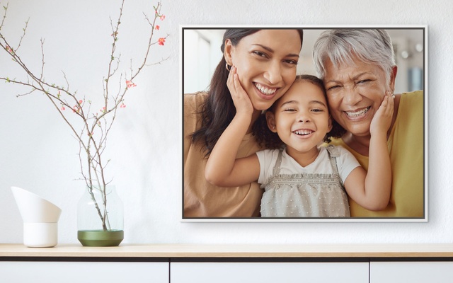 A framed canvas print displaying a photo of 3 generations of women smiling 