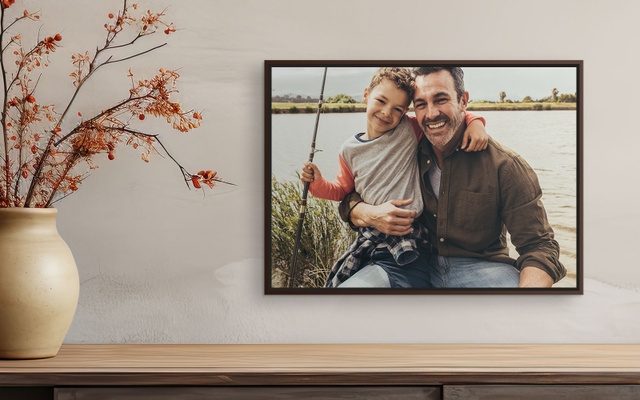 A framed canvas print showcasing a photo of a father and son fishing together