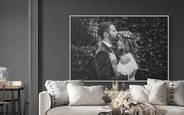 A large black and white framed canvas print of a couple sharing an affectionate moment on their wedding day