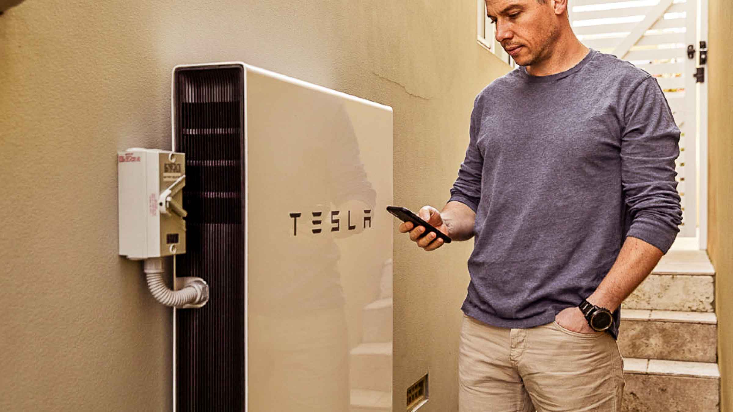 Man checking his energy usage on his Tesla battery